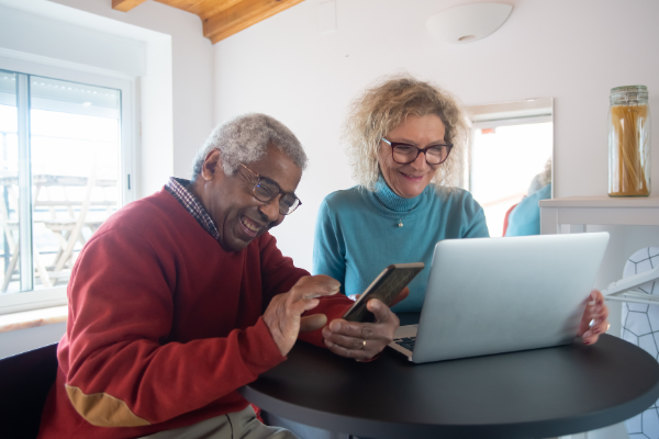 Resources 25 1.png Stock image of a man on his phone and a woman on her laptop smiling.