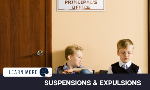Image of two young boys sitting side by side. The wall behind them is tan with a wooden door to the left. There is a sign on the wall reading “Principal’s Office”. One boy is looking at the other with a smile of his face. The other boy is looking down with a frown. Below the image is a black box with white text reading “SUSPENSIONS & EXPULSIONS”. To the left is a white box with dark blue text reading “LEARN MORE” with and orange and blue cursor icon graphic to the right.