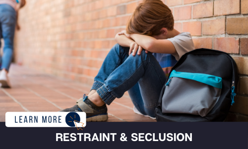 Image of a boy sitting on the ground outside of a building beside his backpack. His arms are folded on his bent knees and his head is resting sullenly on his arms. Below the image is a black box with white text reading “RESTRAINT & SECLUSION”. To the left is a white box with dark blue text reading “LEARN MORE” with and orange and blue cursor icon graphic to the right.